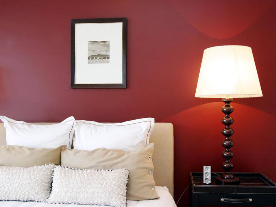 Red Wine Coloured Feature Wall with Cream Coloured Bedsheets